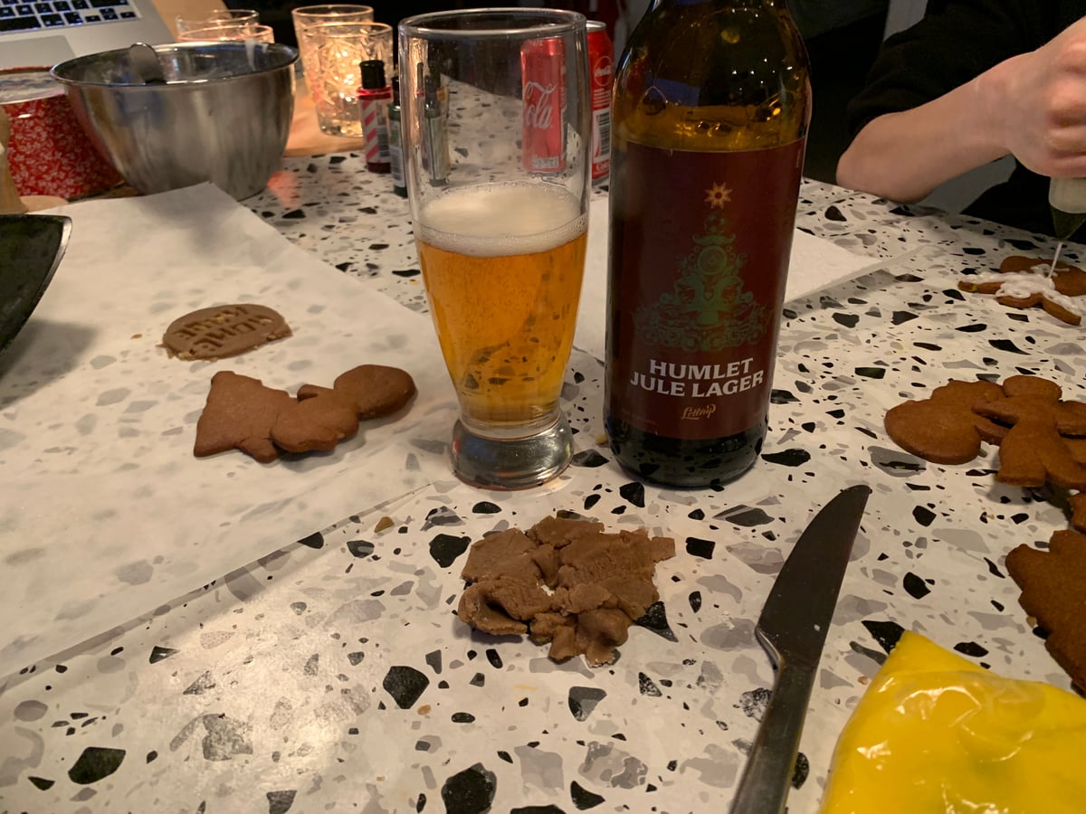 Flaske Lottrup Humlet Jule Lager ved siden af et glas gylden øl og julesmåkager