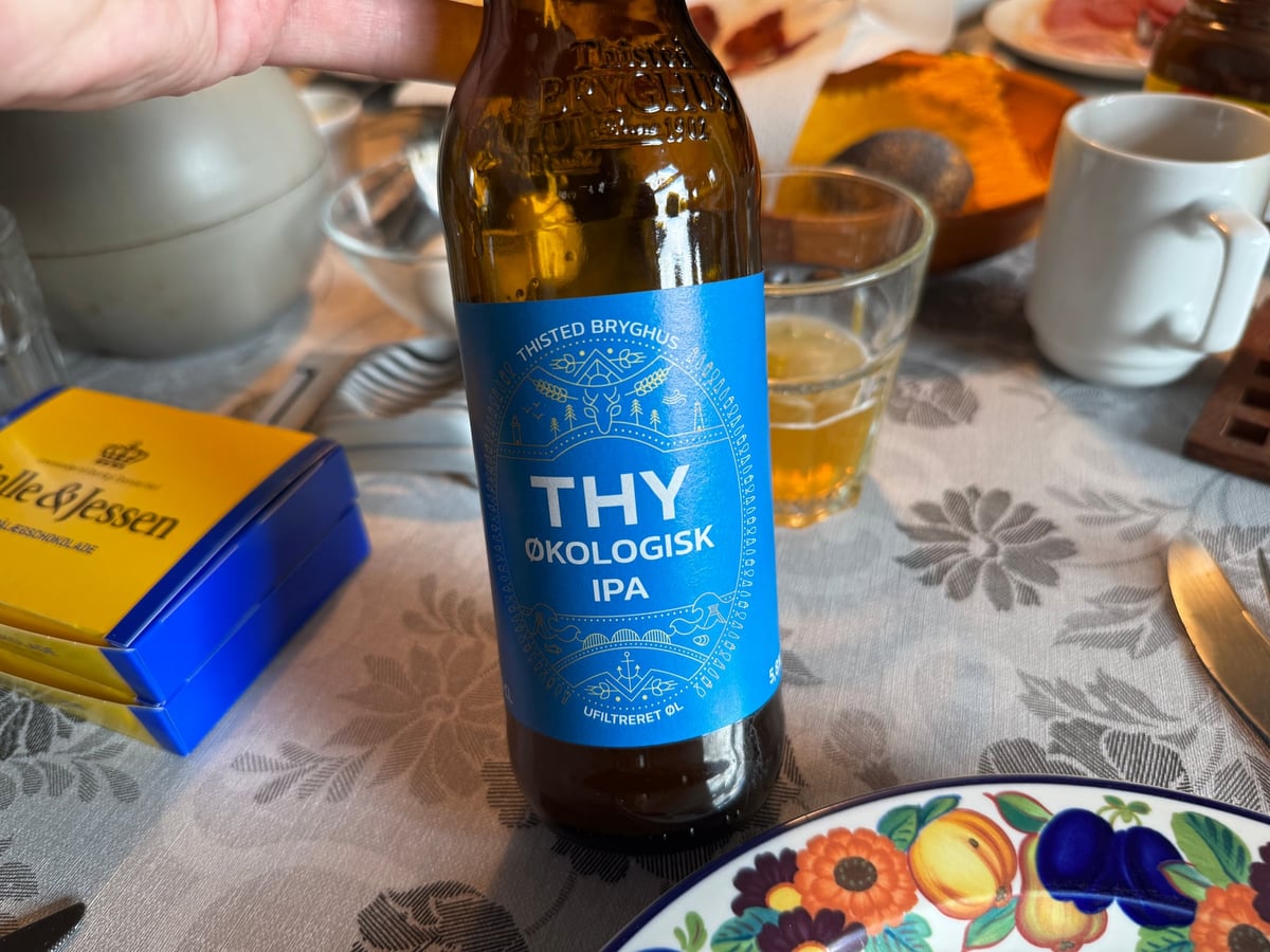 Flaske Thy Økologisk IPA fra Thisted Bryghus foran et glas gylden øl